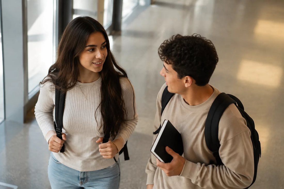 Dois estudantes de mochila continuam a discussão no corredor depois da sessão